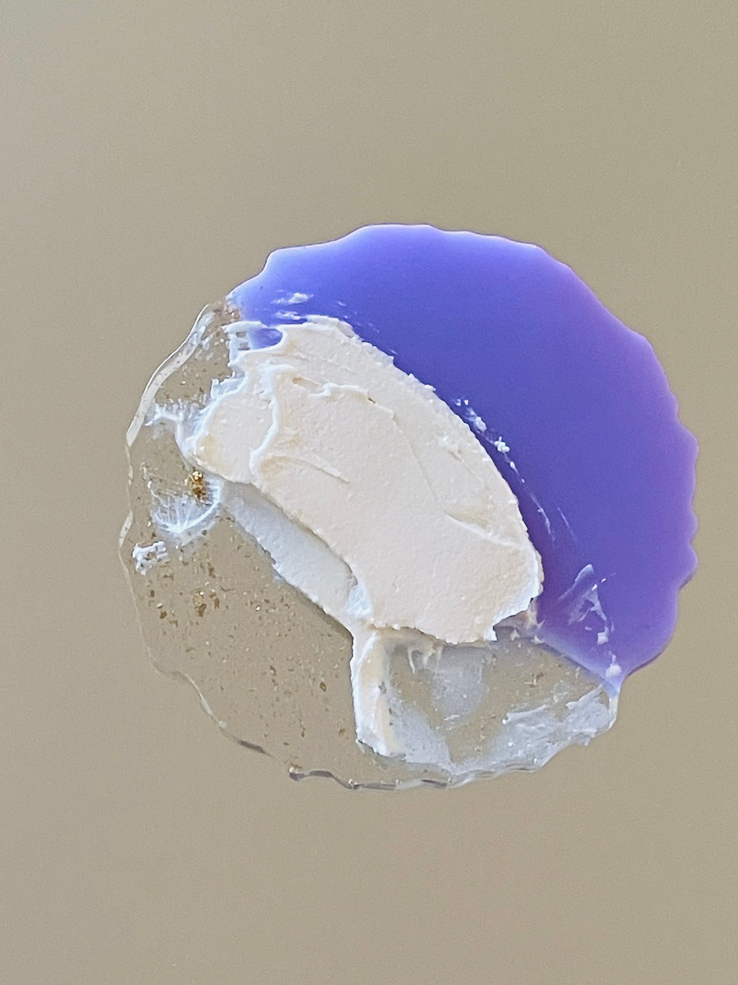Close-up of a crystal with purple and white colors on a beige background